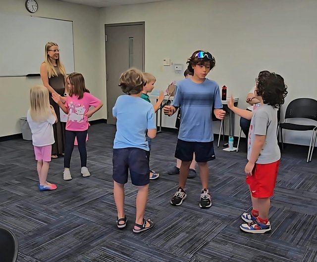 A child stepping across paper plates during a Life Skills Labs relay game